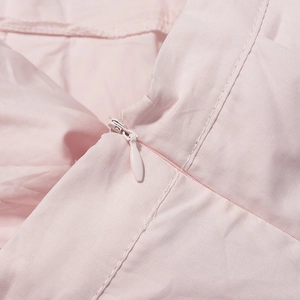 Détail de la fermeture éclair invisible et des coutures sur l'ensemble jupe rose
