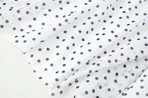 Macro view of white breathable mesh fabric with black polka dot patterns and fine texture