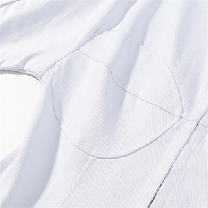 Dettaglio del tessuto in saia bianca con cuciture strutturali e taglio slim fit curato