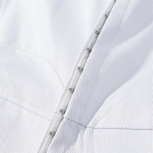 Dettaglio di giacca in cotone bianco con chiusura minimalista a gancio in metallo