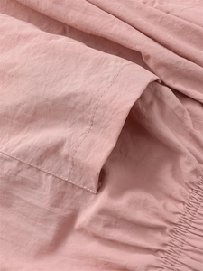 Vue macro du tissu rose pastel avec poche renforcée et ourlet élastique à cordon serré