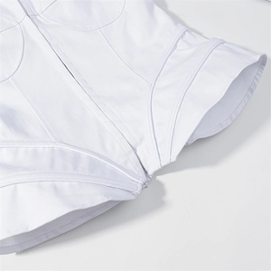 Dettaglio ravvicinato del corsetto bianco con cuciture strutturate e tessuto in twill