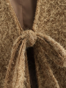 Dettaglio ravvicinato di cardigan in maglia mohair marrone con lacci e texture morbida