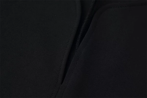 Gros plan du tissu tricoté noir montrant des coutures précises et des détails de finition