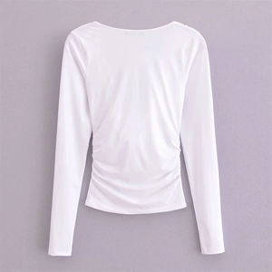 Rückansicht eines weißen Langarm-Crop-Tops mit seitlicher Raffung und rundem Halsausschnitt