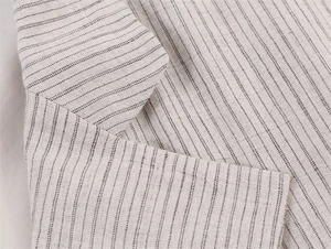 Primer plano de la solapa y textura de rayas en el blazer beige de mezcla de lino