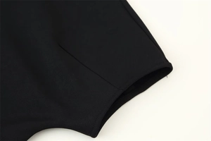 Détail du tissu en maille noire avec des coutures soignées et une finition lisse