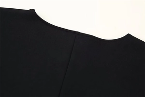 Gros plan du col rond noir avec des coutures précises et une texture de tissu de qualité
