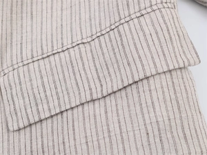 Vista macro de costuras finas en tela de mezcla de lino con rayas beige suave