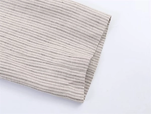 Detalle de tela de mezcla de lino beige con rayas negras en puños y textura del dobladillo