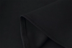 Détail macro du tricot noir montrant des coutures soignées et une texture lisse