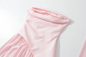 Détail d'une robe rose clair montrant le col bénitier drapé et les plis texturés