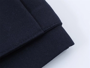 Close-up of navy blue suit fabric showing high-density texture and neat stitching details
