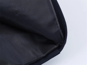 Detailed macro view of black nylon fabric texture with navy blue ribbed knit edging