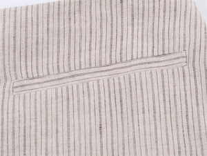 Primer plano de rayas diplomáticas en tela de lino beige con detalle de bolsillo de ojal