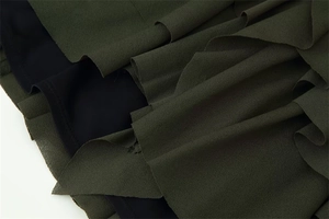 Detail of army green tiered ruffles and black lining on a chic short dress fabric