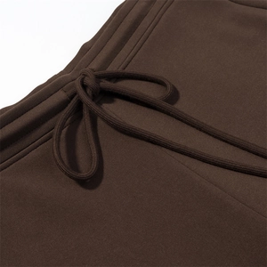 Detail of dark brown knit trousers showing elastic waistband and matching drawstring