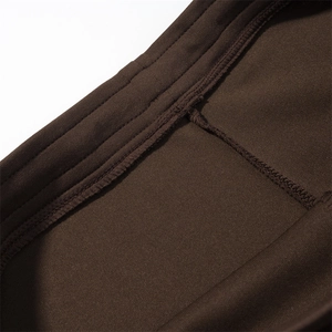 Macro detail of high-quality double-needle stitching on brown flared pants waist