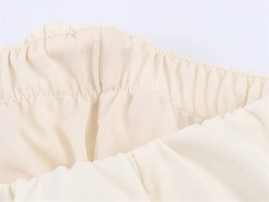 Detailaufnahme des elastischen Bundes und Innenfutters eines beigen Midikleids
