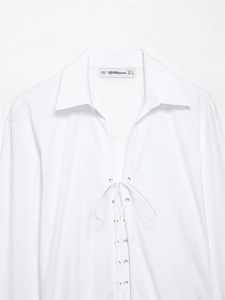 Detail der weißen schmal geschnittenen Popeline-Bluse mit Schnürung und Metallösen
