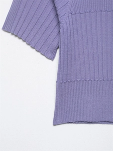 Dettaglio del crop top in maglia a coste lavanda con cuciture decorative a onde