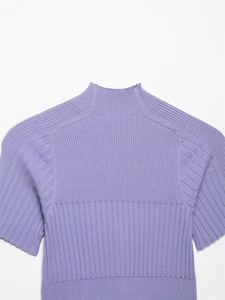 Dettaglio del top in maglia a coste lavanda con collo alto e trama del tessuto fine
