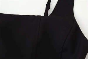 Detailopname van het verstelbare spaghettibandje en de halslijn op de zwarte bodycon jurk