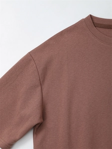 Detail von hochdichtem Baumwollgewebe und feinen Nähten an einem ziegelroten Rundhalsshirt