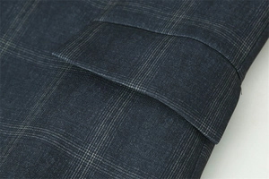 Makro-Detail eines karierten Blazers mit klassischer Taschenklappe und Webstruktur