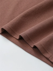 Detail der Doppelnaht am Saum eines gewaschenen Baumwoll-T-Shirts in Kakaobraun
