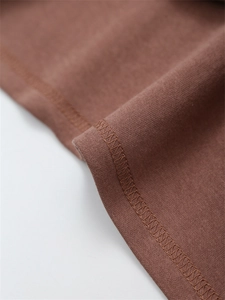 Detail aus hochwertigem braunem Baumwollstoff mit Overlock-Nähten und feiner Verarbeitung