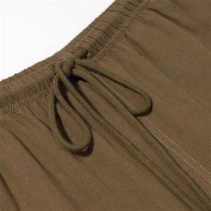 Dettaglio di pantaloni casual marrone scuro con vita elastica e coulisse intrecciata