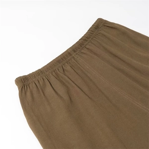 Dettaglio dell'elastico in vita marrone con coulisse e tessuto strutturato dei pantaloni casual