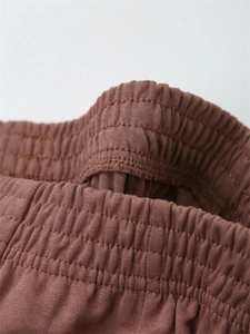 Detailaufnahme brauner Baumwoll-Leinen-Hose mit elastischem Bund und feinen Nähten