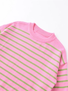 Detail of pink and green striped knit sweater showing texture and ribbed cuffs