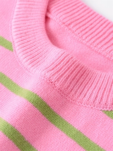 Detail of pink knitted sweater collar with green stripes and ribbed neckline texture