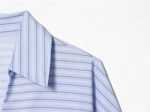 Gros plan détaillé montrant les coutures fines et les rayures bleues du col de chemise