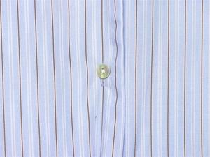 Détail macro du tissu à rayures bleues avec un bouton en nacre sur la chemise