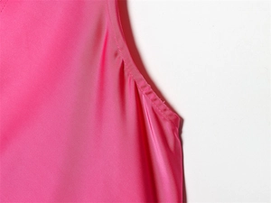 Gros plan détaillé du haut sans manches rose montrant le tissu satiné et les coutures soignées