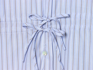 Détail d'une chemise à rayures bleu clair avec double nœuds et bouton nacre