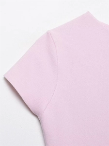 Gros plan sur la maille fine et les coutures de l'encolure de ce haut rose à manches courtes
