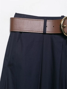 Dettaglio vita dei pantaloni a gamba larga con cintura marrone e fibbia dorata