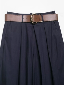 Dettaglio dei pantaloni blu navy a vita alta con pieghe e cintura marrone con fibbia dorata