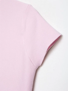 Gros plan détaillé des coutures d'épaule et de la texture du haut en maille rose