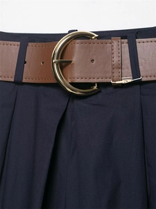Dettaglio dei pantaloni a gamba larga blu navy con cintura marrone e fibbia dorata a ferro di cavallo