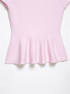 Vue détaillée du haut en tricot rose montrant la texture fine et le volant péplum