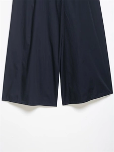 Dettaglio dell'orlo a gamba larga dei pantaloni indaco scuro con effetto drappeggiato