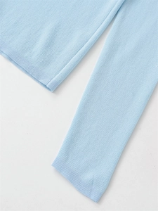 Detailed macro view of light blue ribbed knit texture and premium stitching on the sleeve