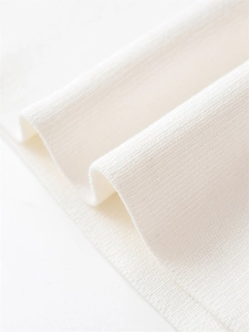 Détail macro de la texture en maille côtelée fine et du tissu blanc doux sur le poignet