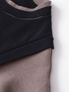 Dettaglio del top in maglia bicolore con cuciture raffinate sullo scollo nero e marrone